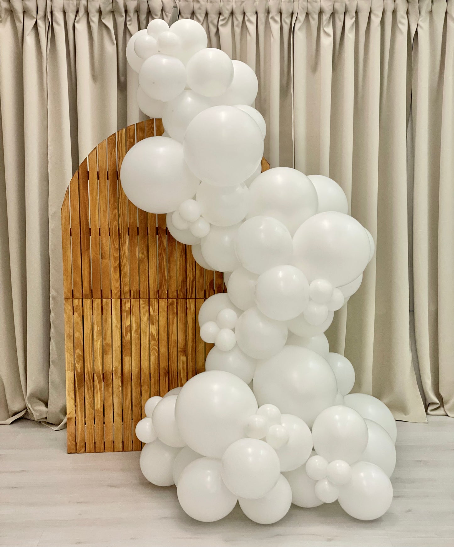 Hvit ballongbue til bryllup, dåp konfirmasjon. Store og små ballonger foran en beige bakgrunn. Finst i tre forskjellige størrelser